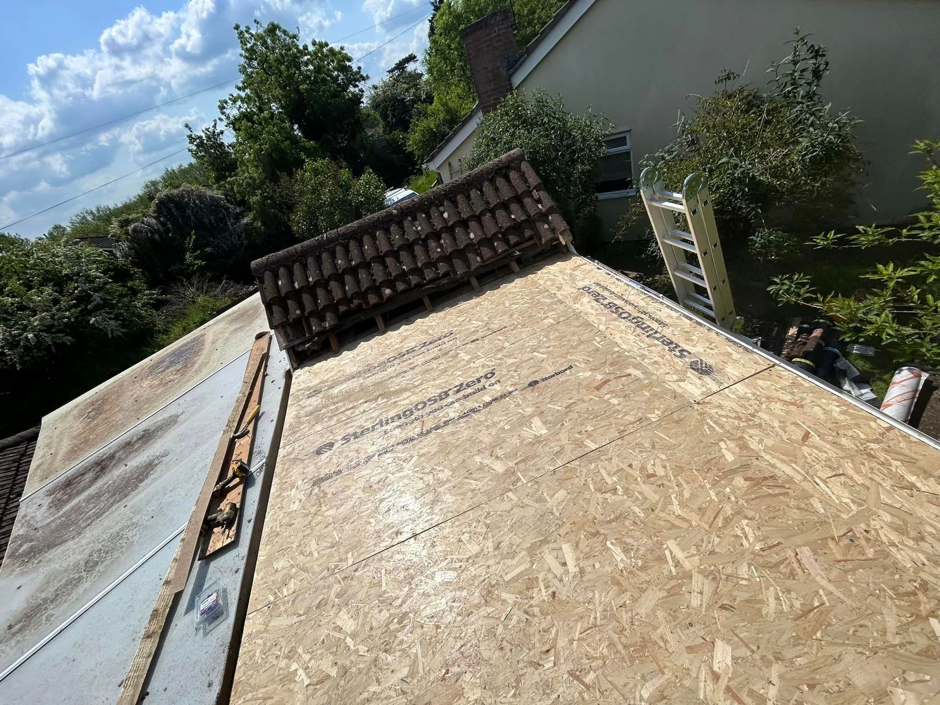 The roof of a house is being remodeled with a wooden roof base.