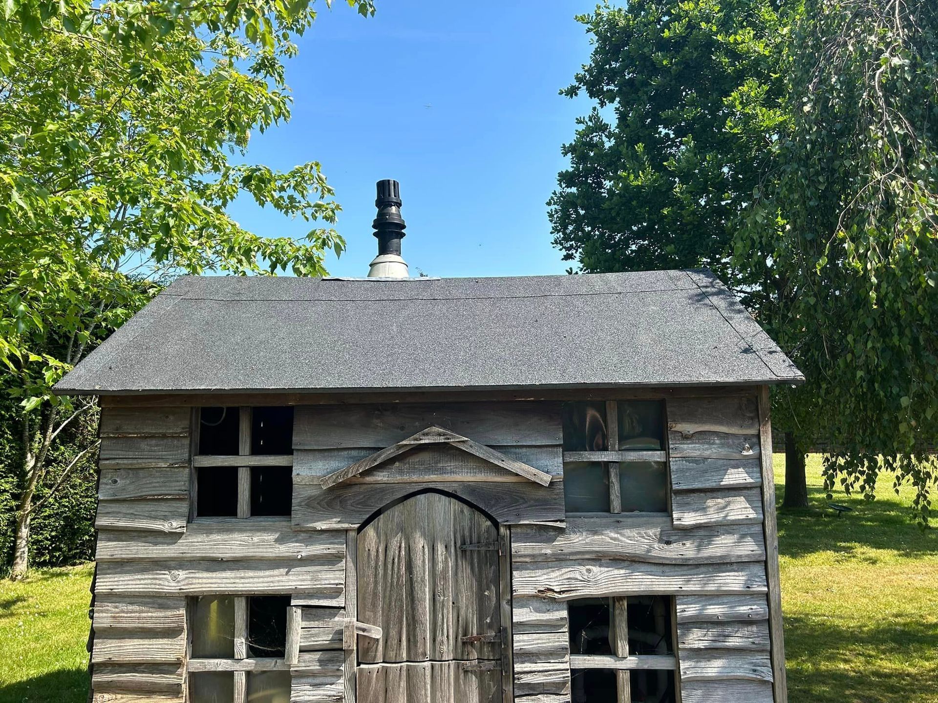 A small wooden house with a chimney on top of it