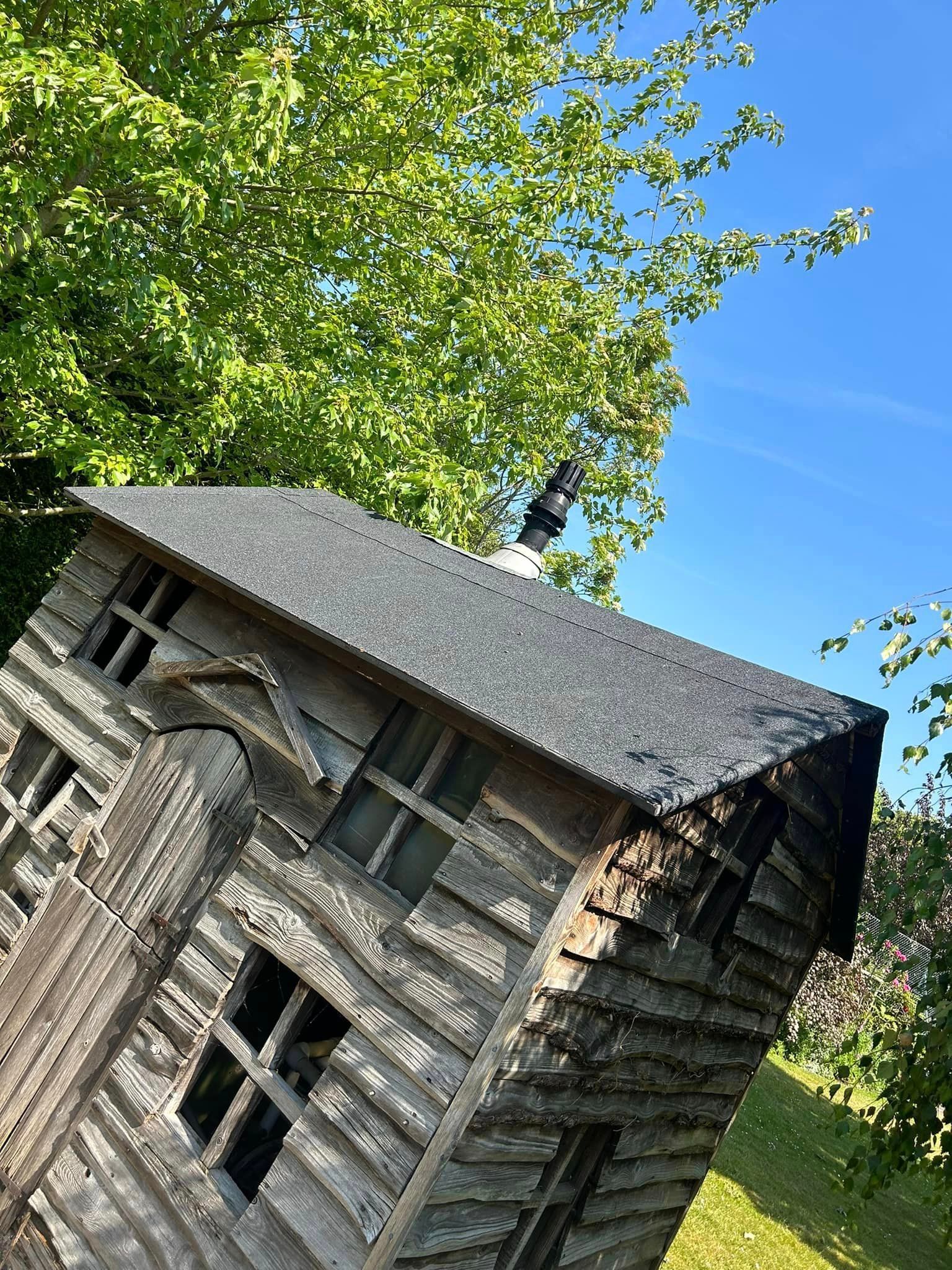 A small wooden house is sitting in the middle of a field.