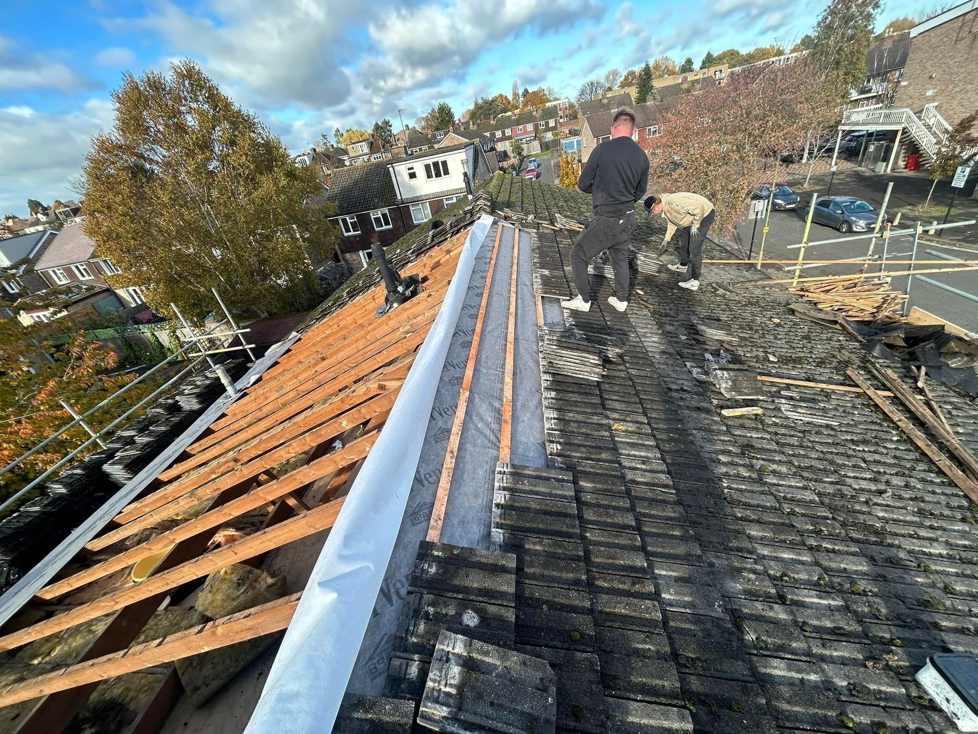 A man is standing on the tiled roof of a building.