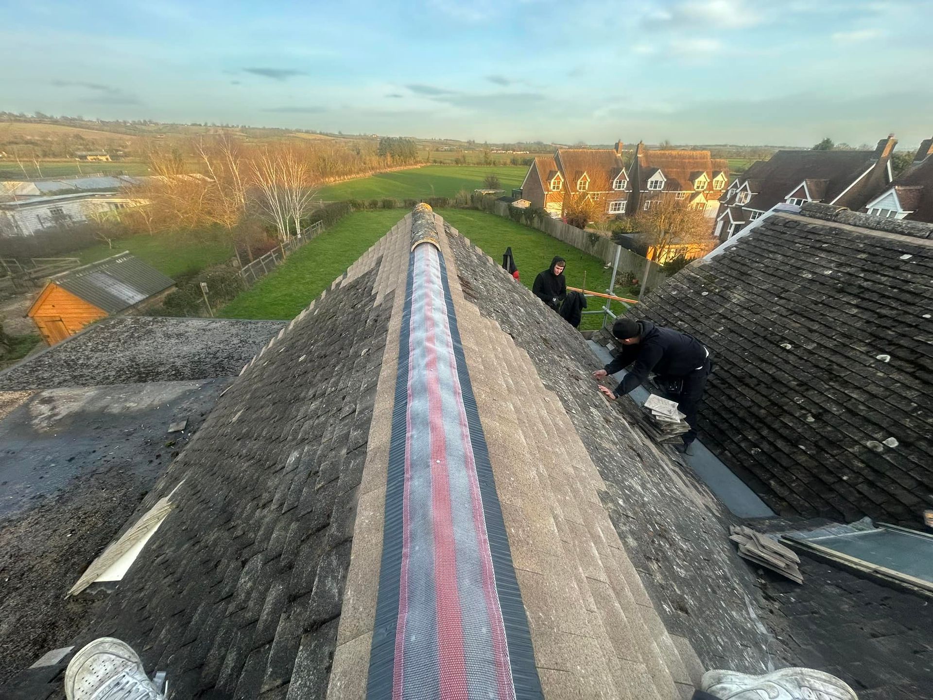 A group of people are working on the roof of a building.