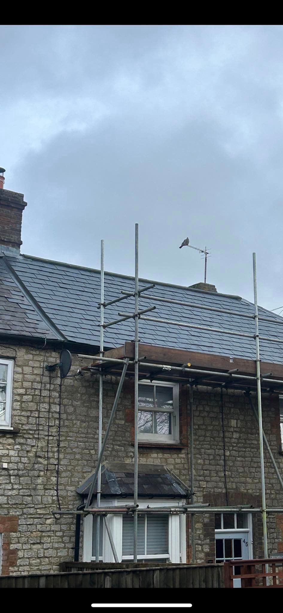 A house with a roof that is being built and a scaffolding around it.