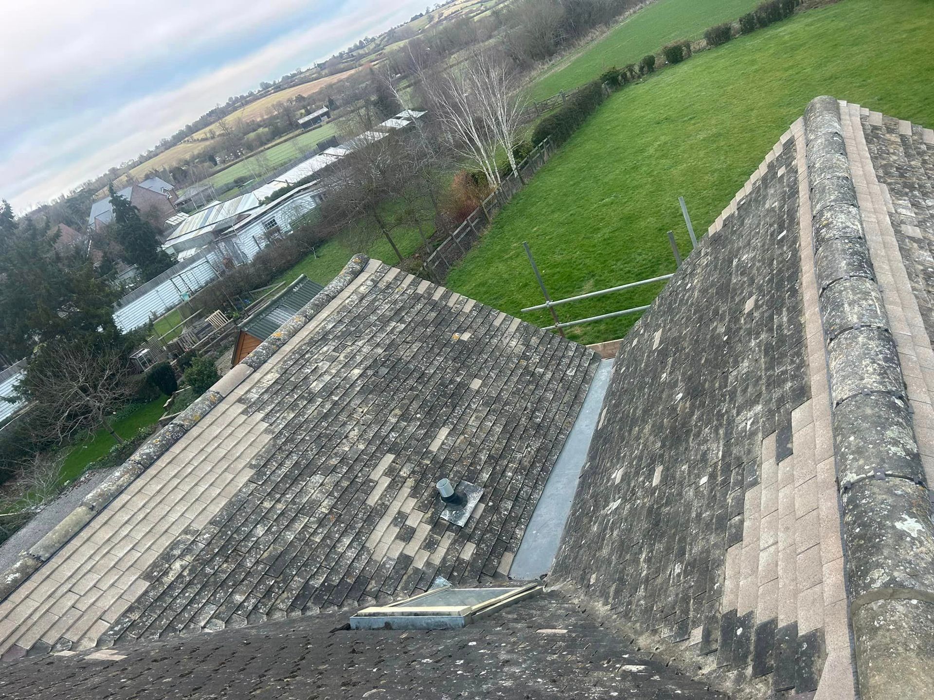 An aerial view of a roof with a field in the background
