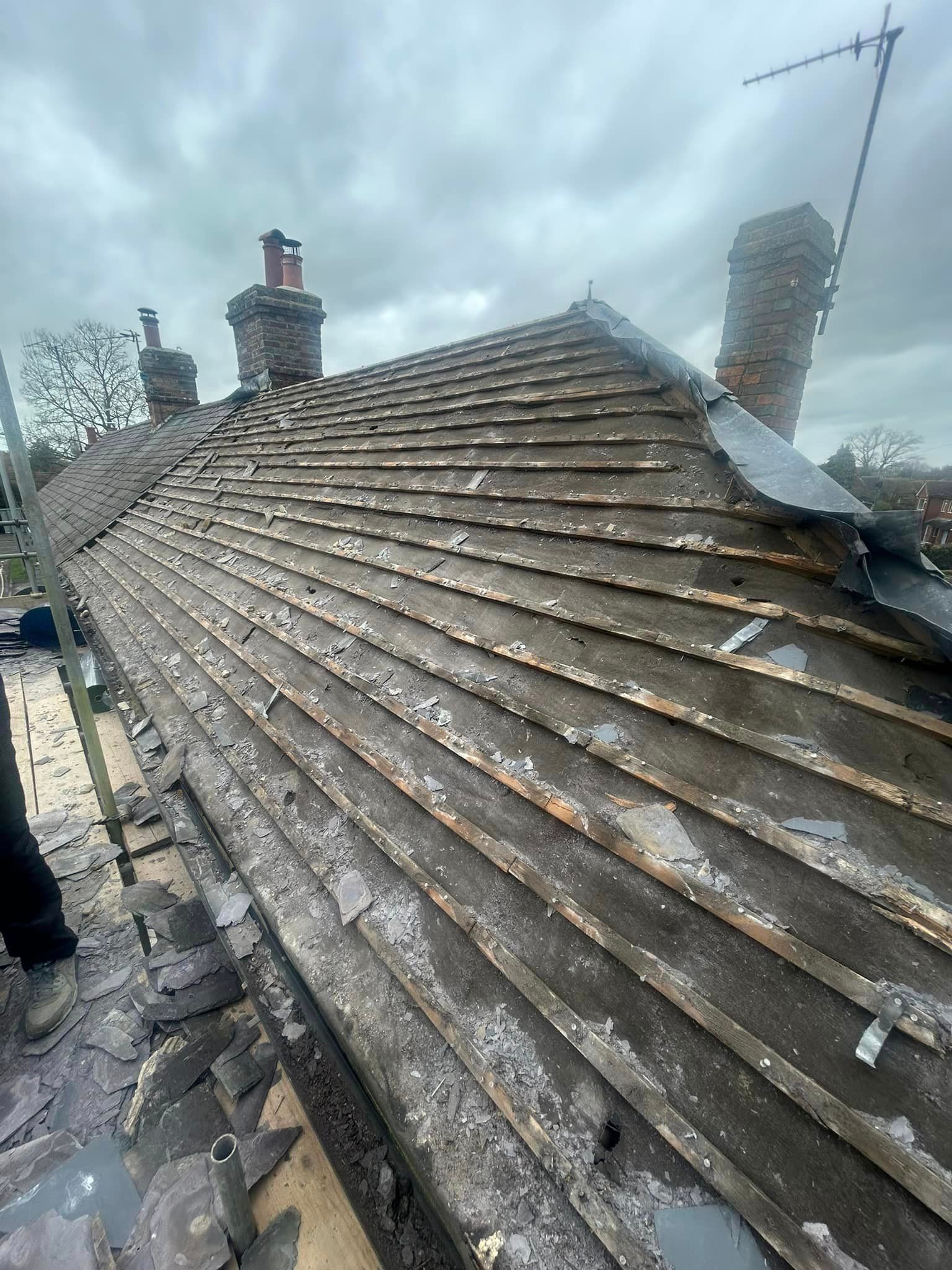 A roof with a lot of tiles on it is being repaired.