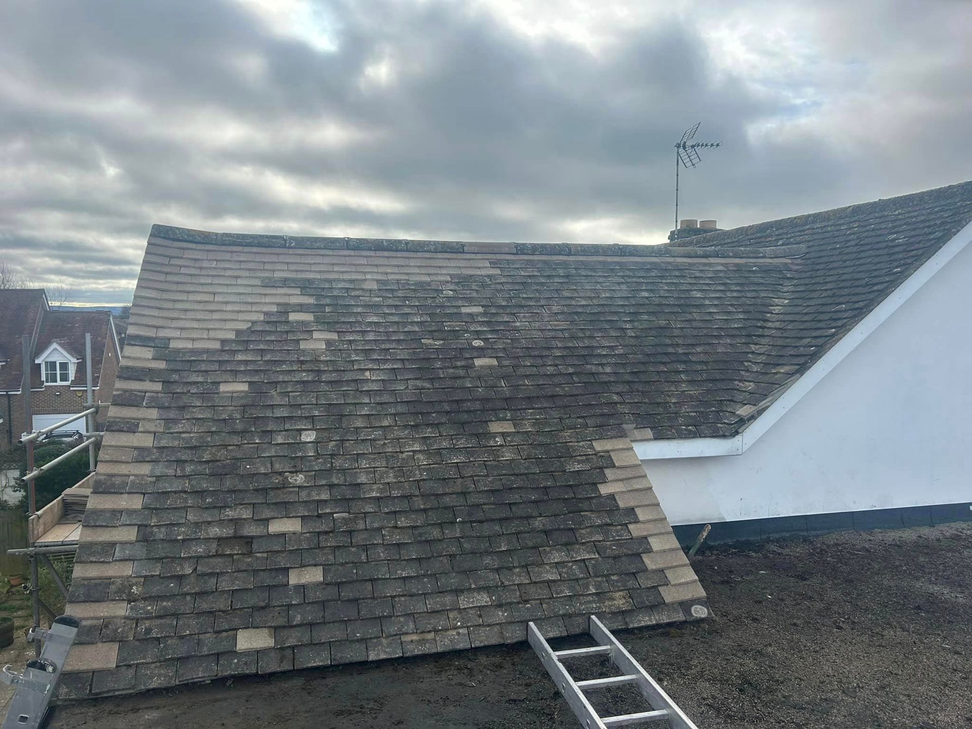 A ladder is sitting on the roof of a house.