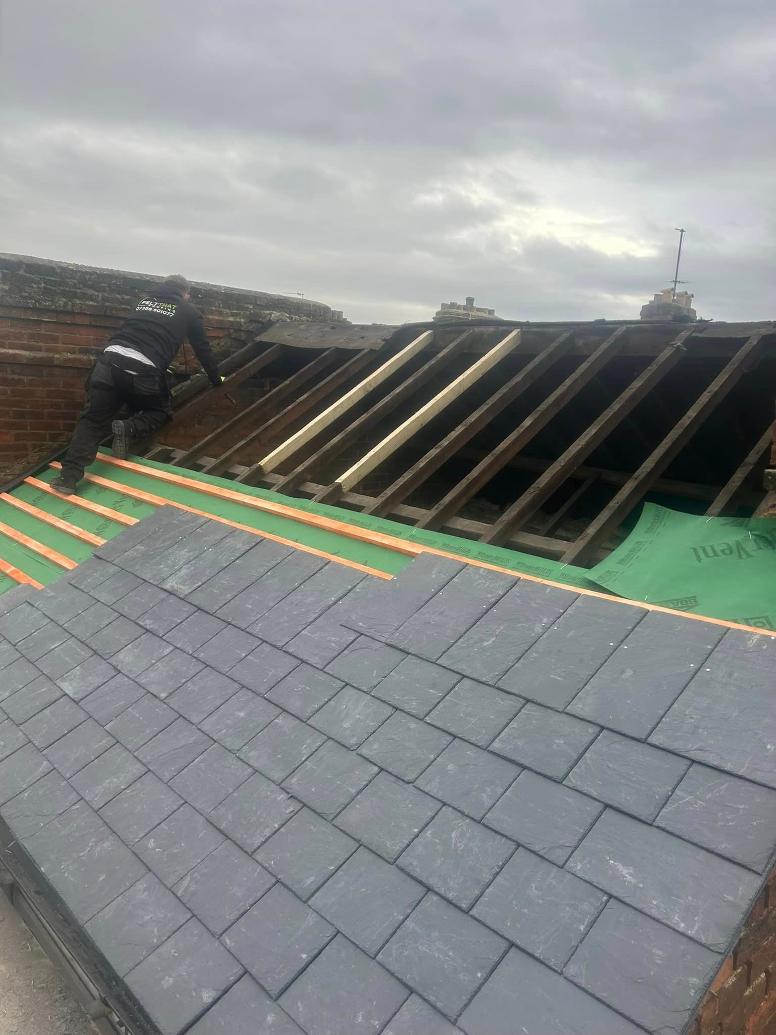 A man is working on the roof of a building.