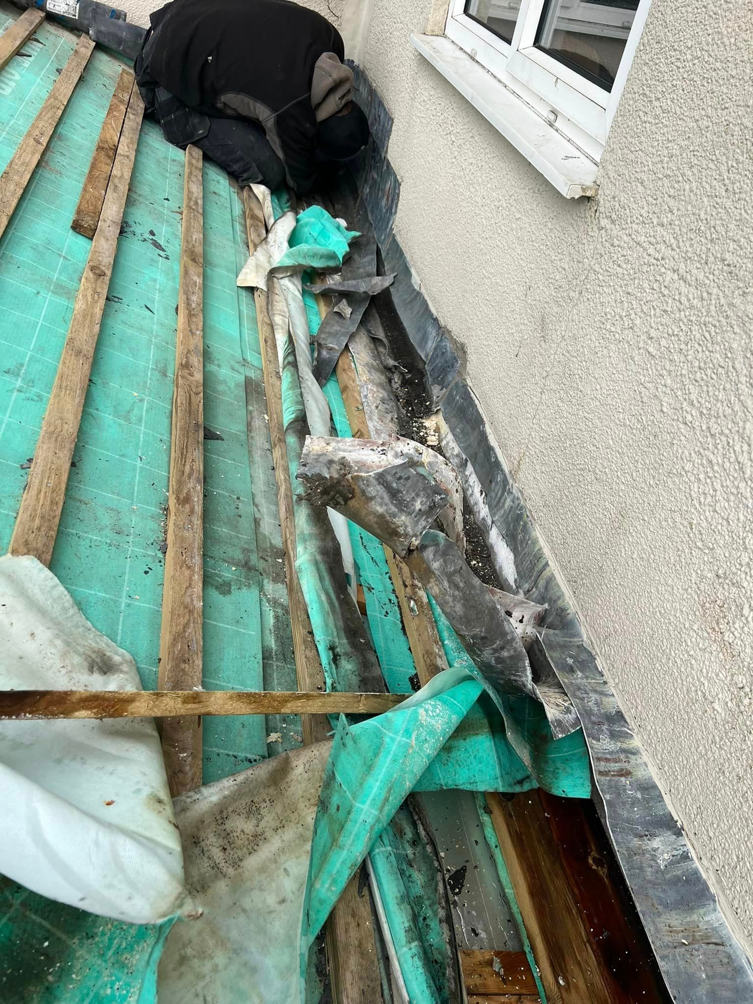 A man is laying on the roof of a building.