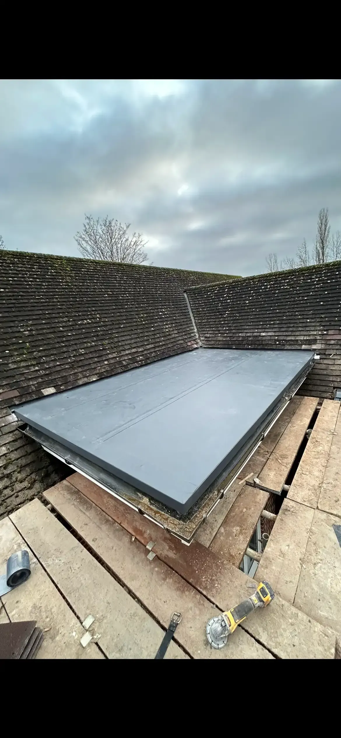 A large piece of concrete is sitting on top of a wooden roof.