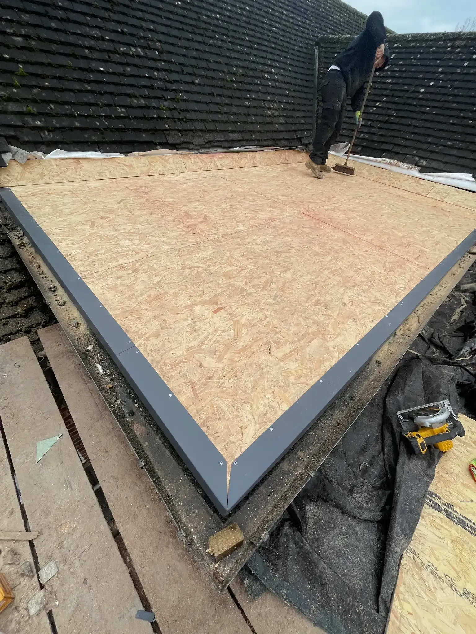 A man is working on the roof of a building.