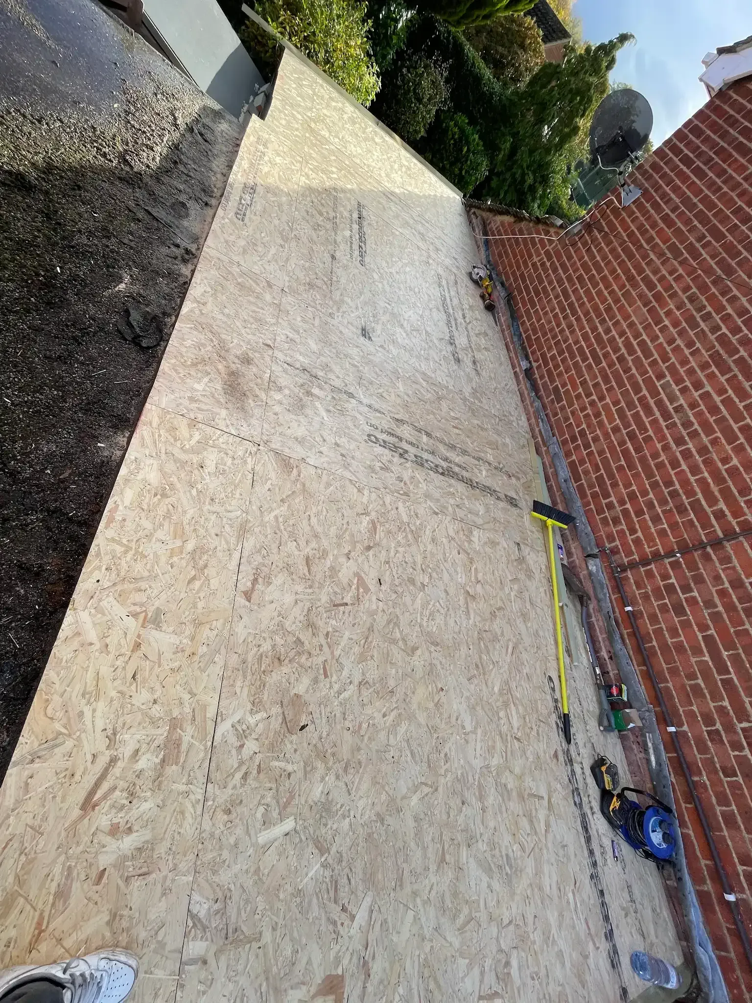 A large piece of plywood is on a roof under construction