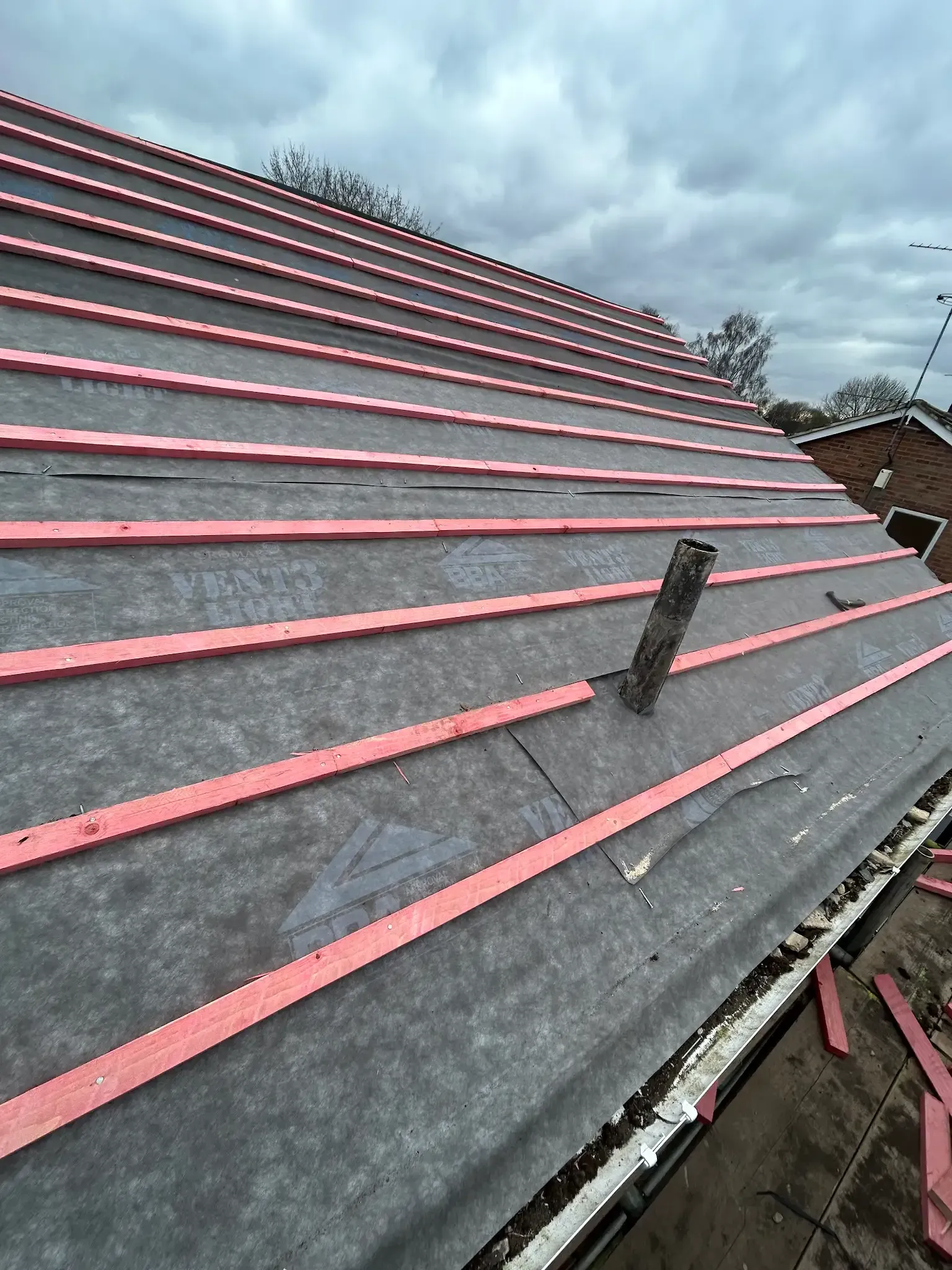 A roof with red stripes on it is being built.