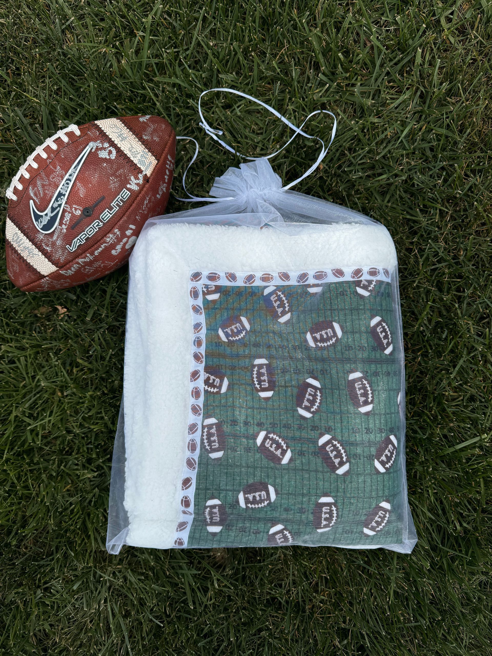 sherpa blankets with printed material that has footballs on the fabric
