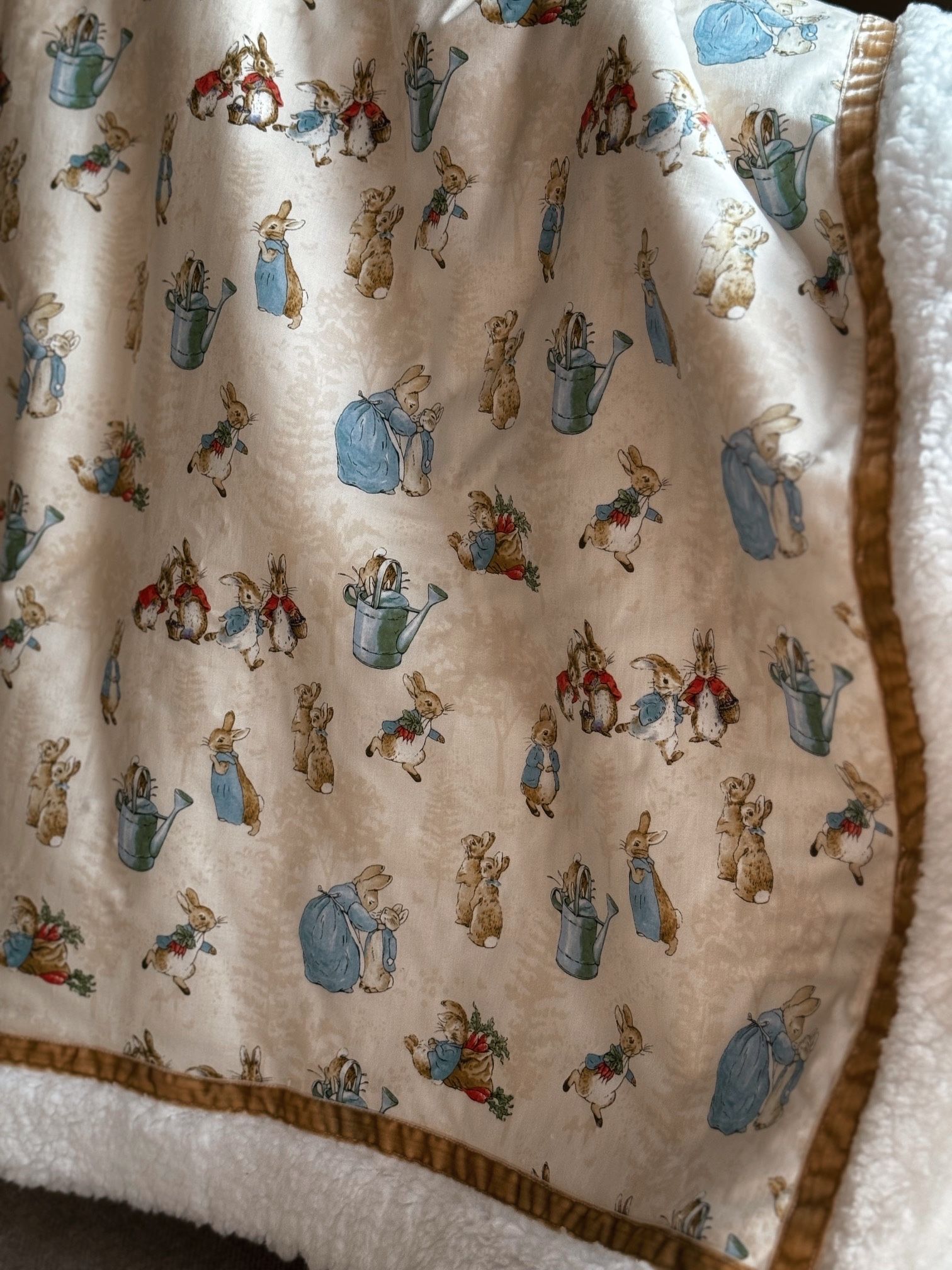 sherpa blankets with printed material that has peter rabbit on the fabric  and stuffed animal