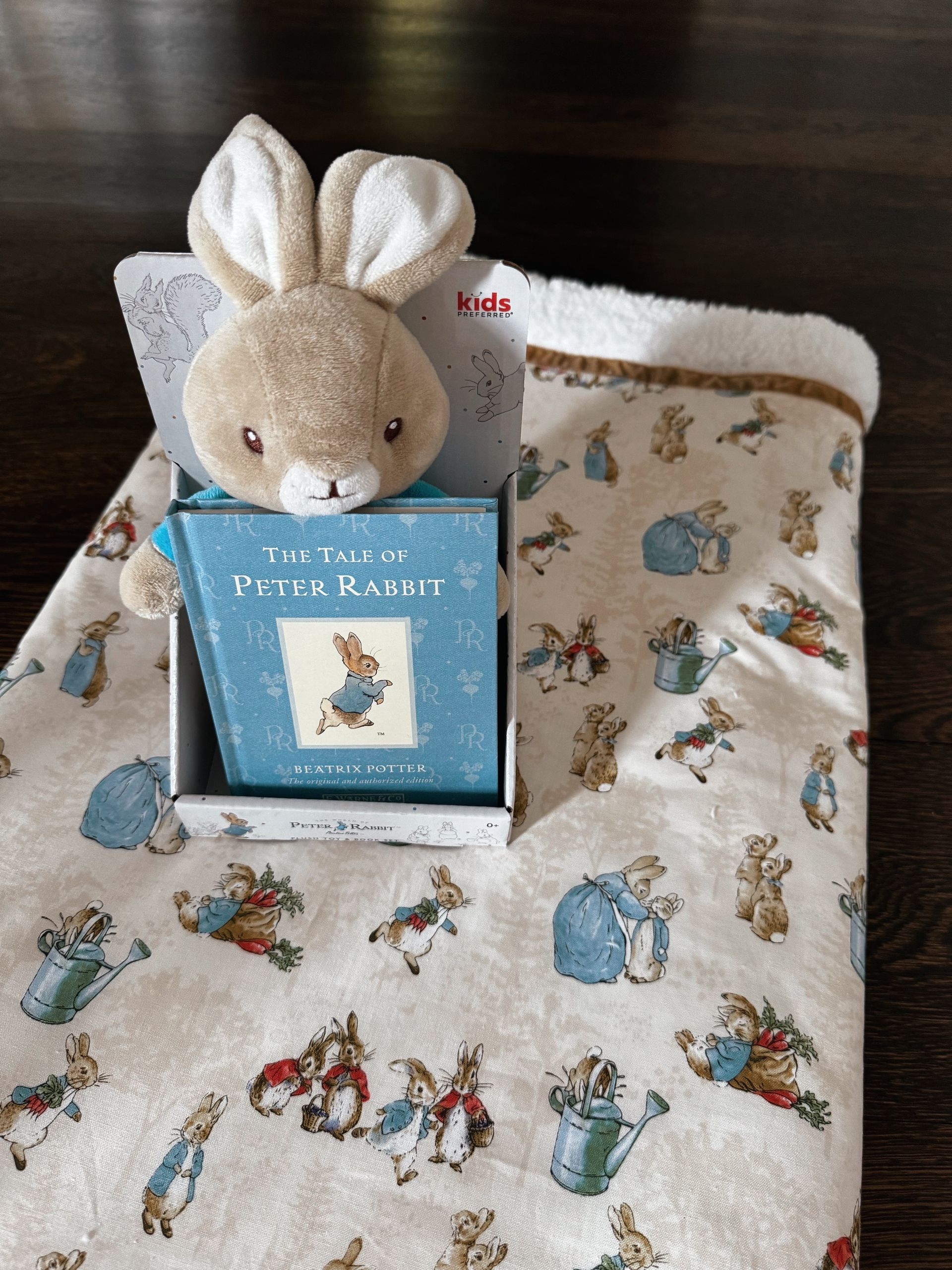 sherpa blankets with printed material that has peter rabbit on the fabric  and stuffed animal