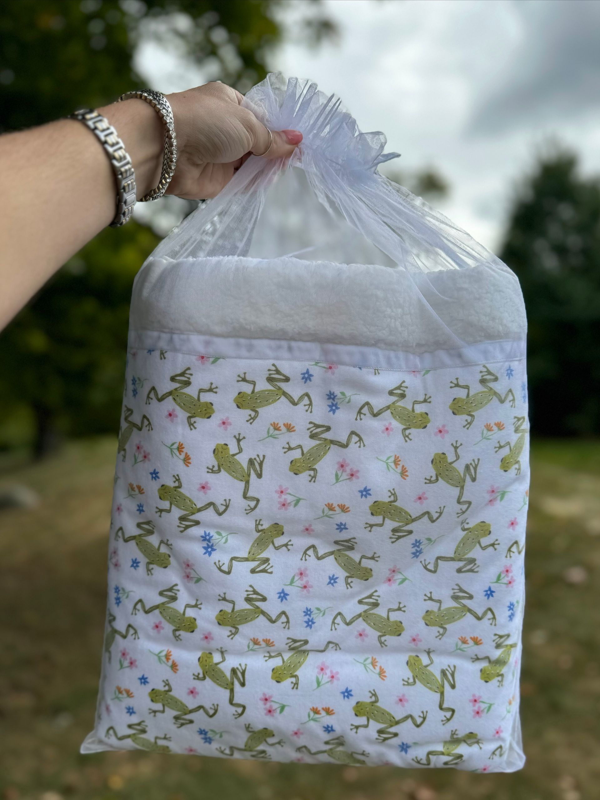 sherpa blanket with frogs all over wrapped in organza bag