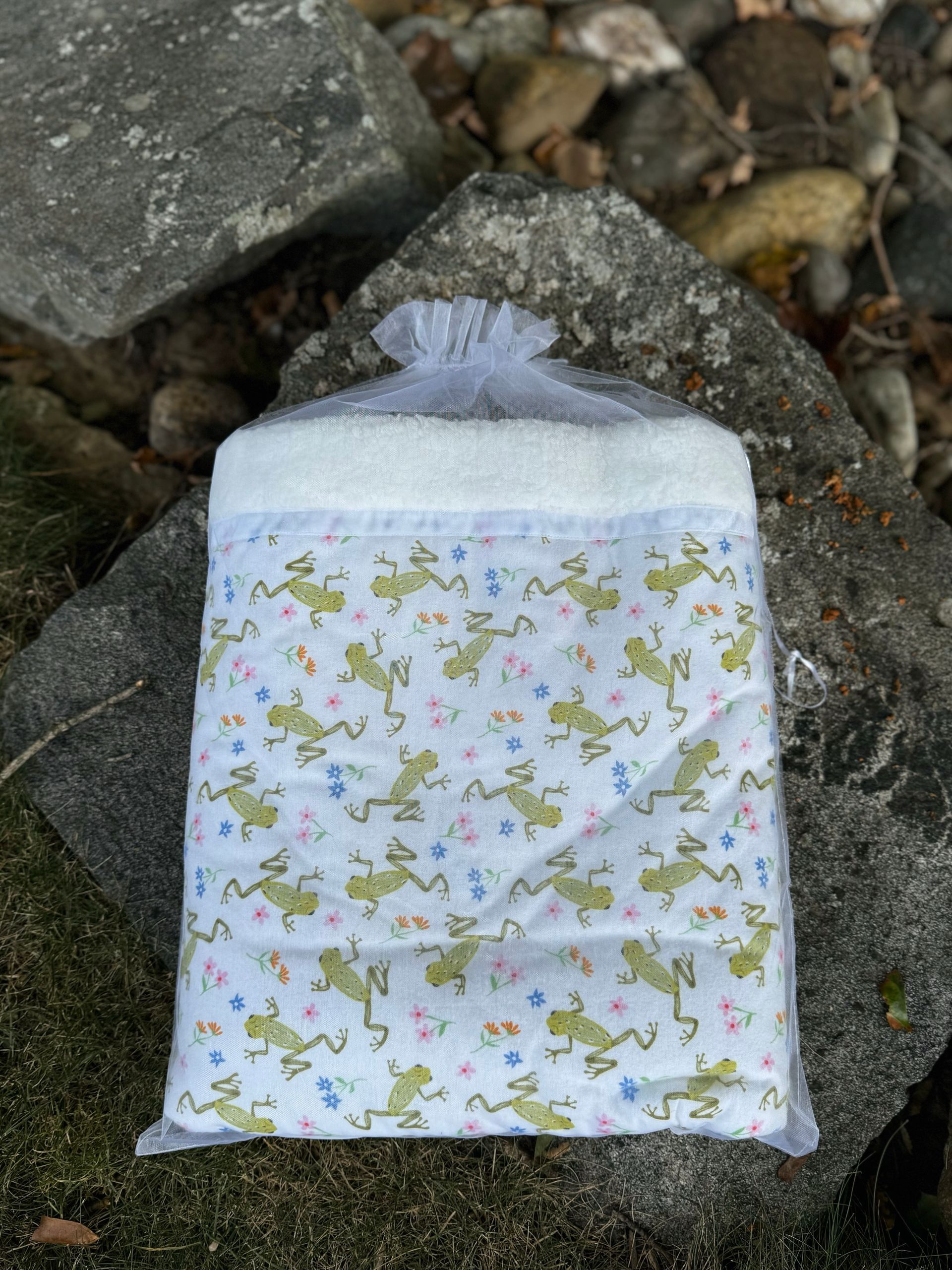 sherpa blanket with frogs all over wrapped in organza bag