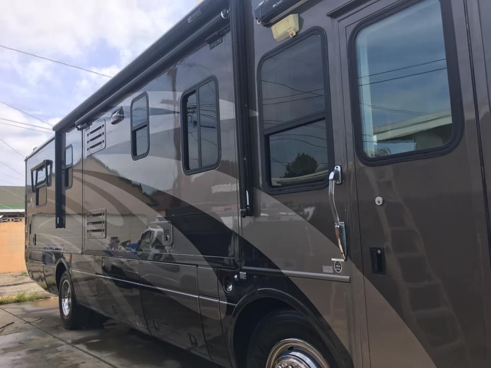 A large rv is parked on the side of the road.