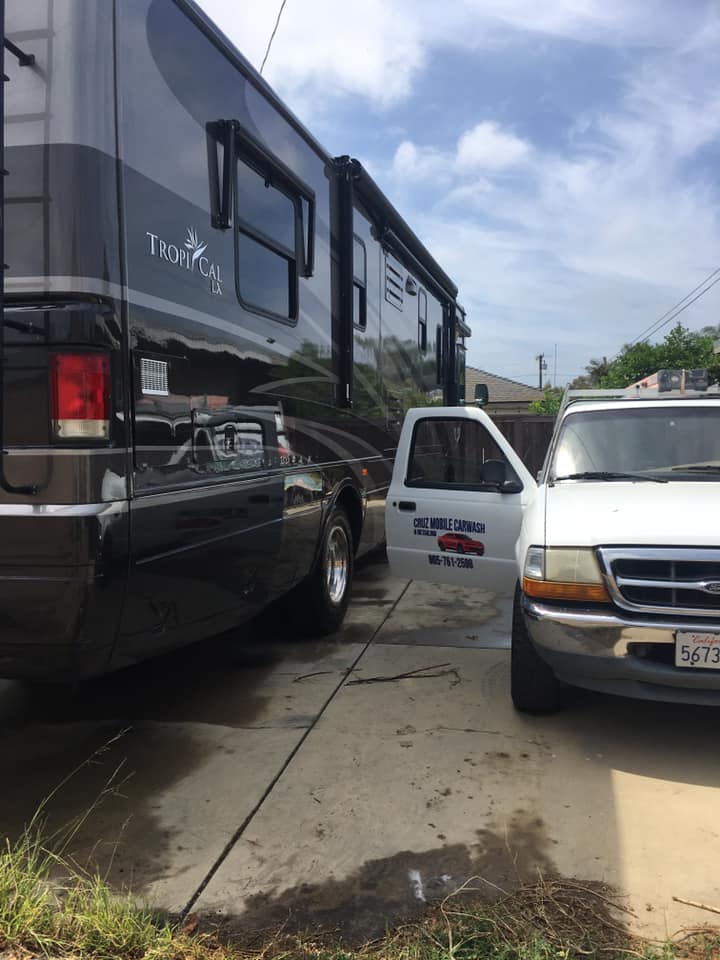 A truck is parked next to a rv in a driveway