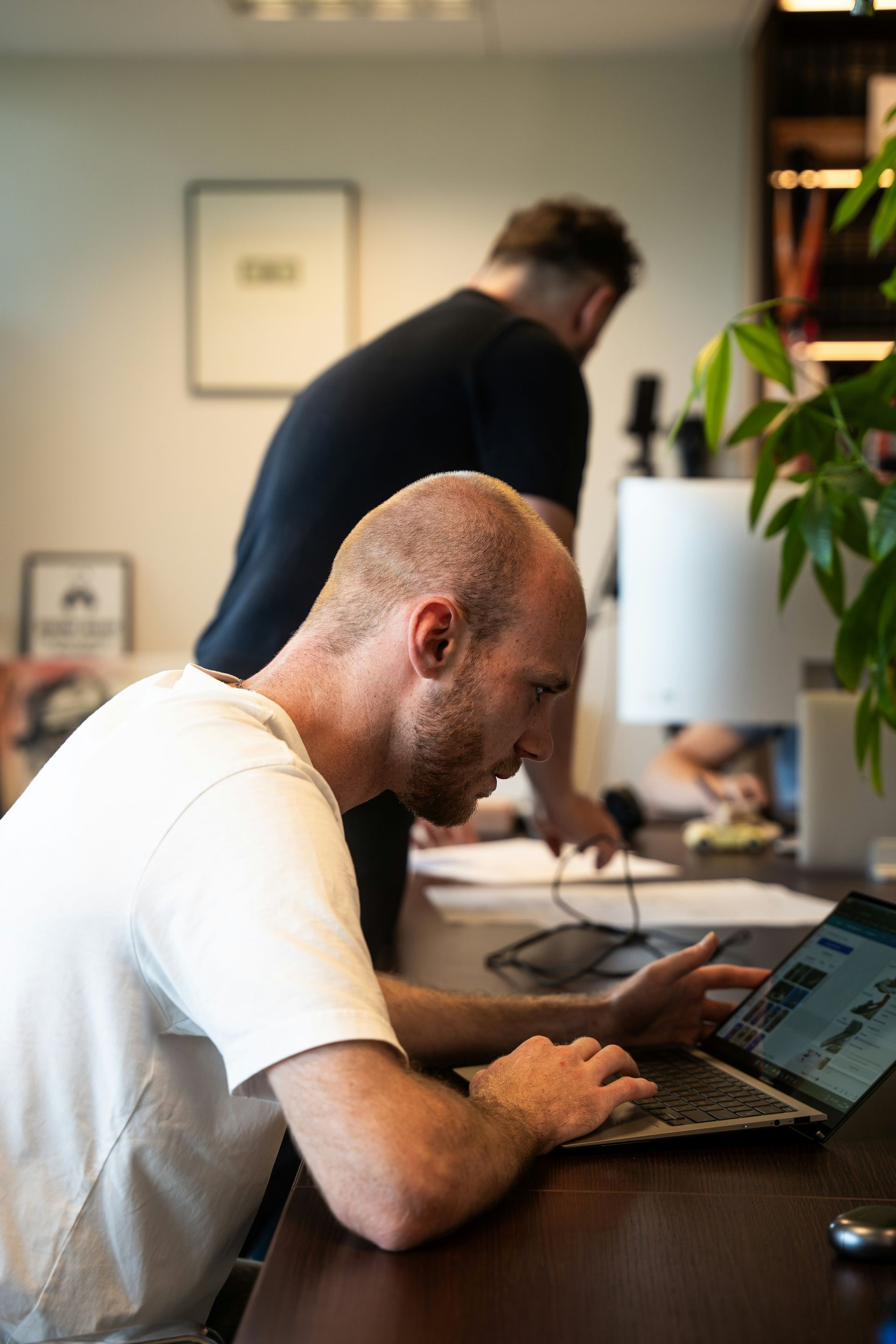 A woman in a red sweater is sitting on a chair holding a cup of coffee.