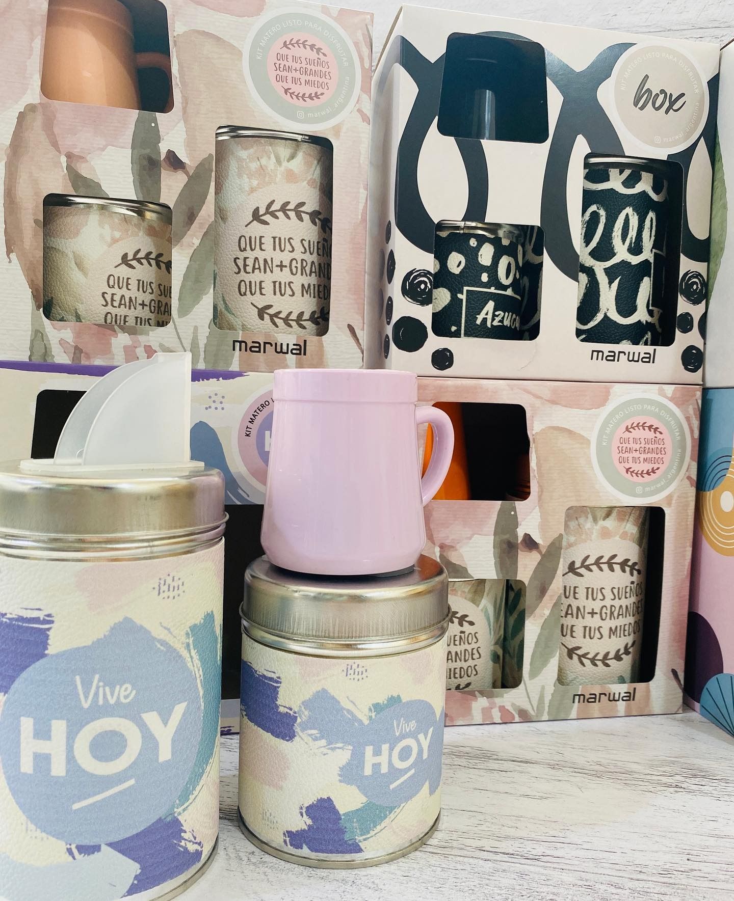 Cajas de regalo con frascos ilustrados, tazas y caja de pañuelos, en varios colores.