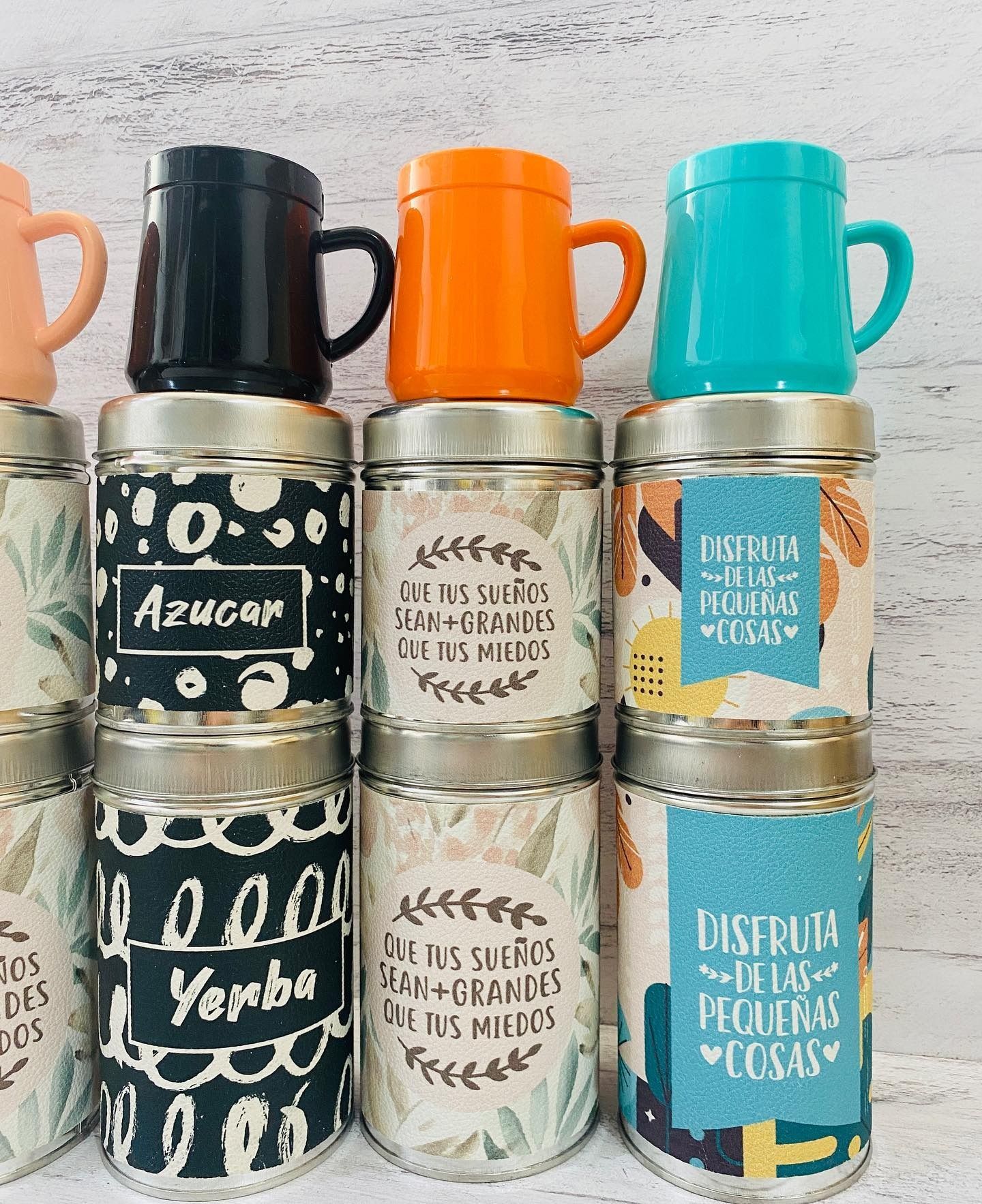 Tazas coloridas sobre frascos de vidrio etiquetados. Etiquetas visibles de 