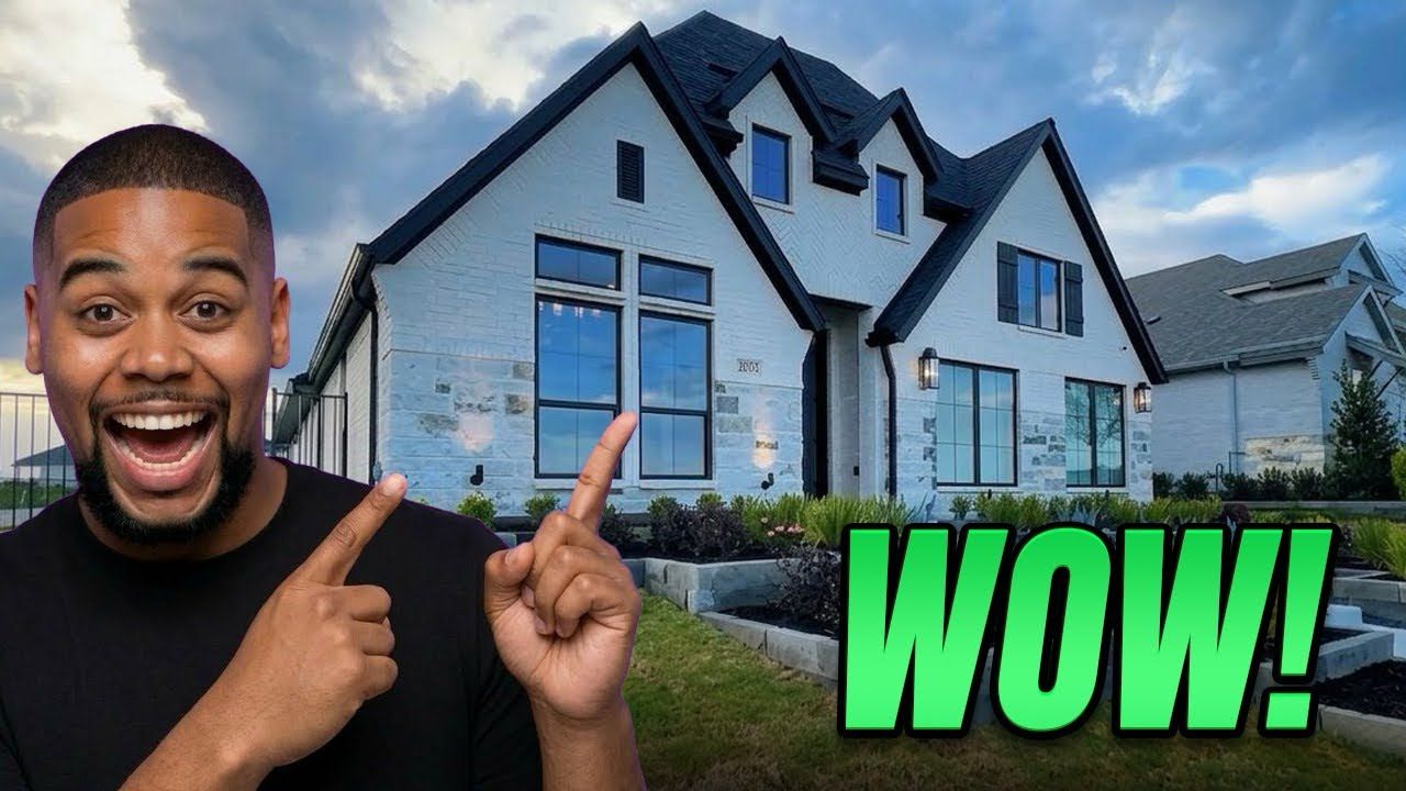 A person smiles and points at a modern, two-story white house with dark trim. Text overlay says 