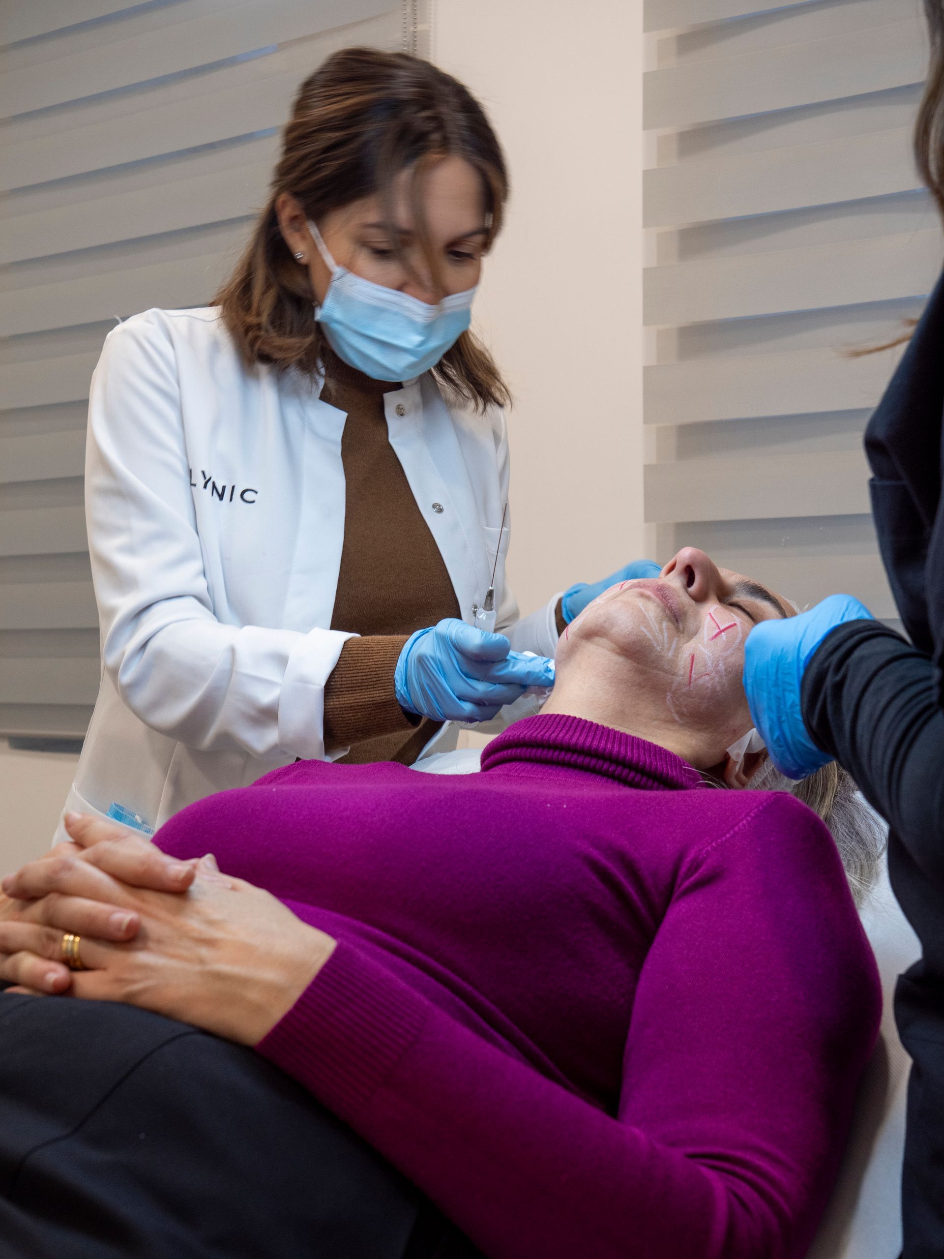 Una donna che indossa una mascherina sta offrendo un trattamento viso a un uomo.