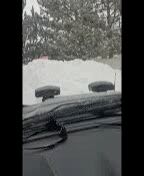 The windshield of a car is covered in snow.