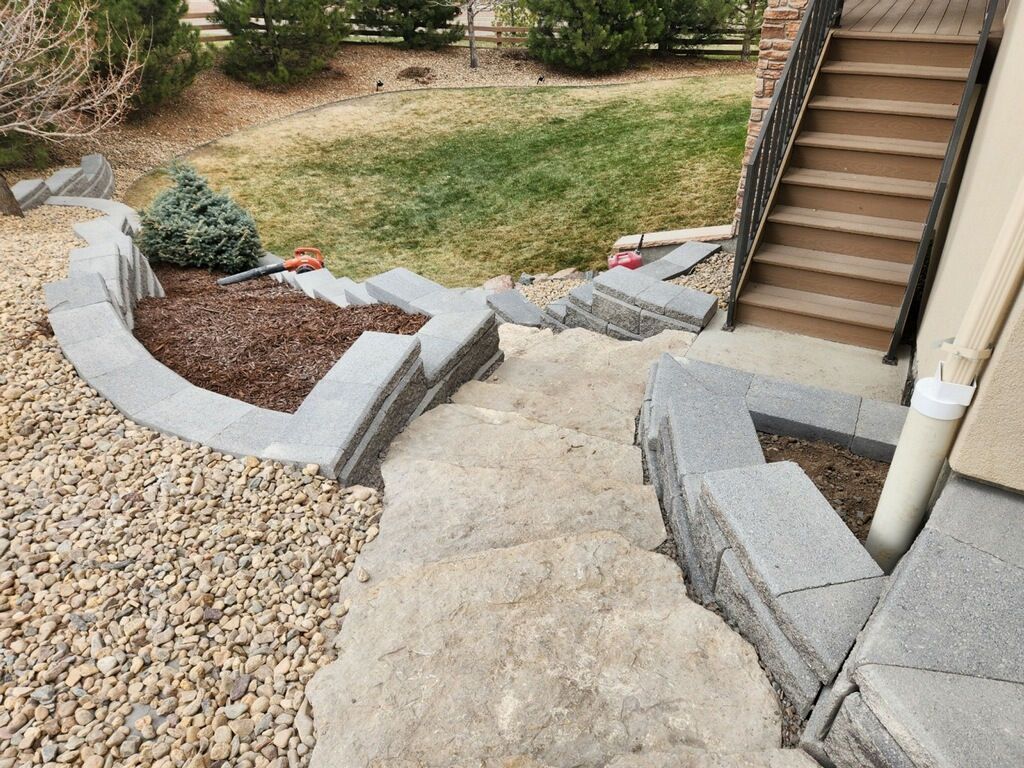 A set of stairs leading up to a house surrounded by rocks and gravel.