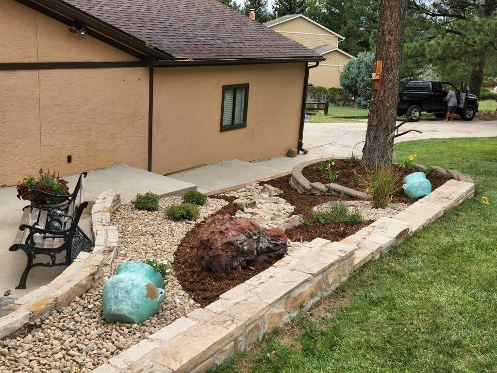 A house with a garden in front of it and a truck parked in the driveway.