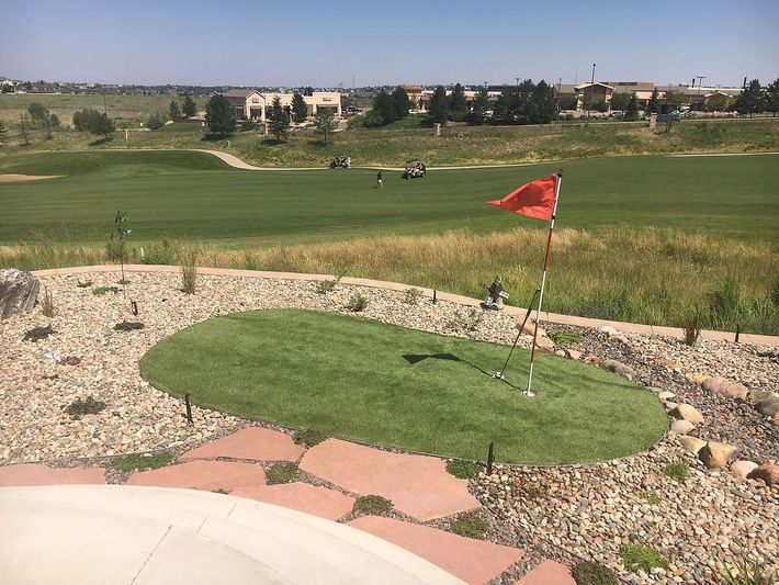 A golf course with a red flag in the middle of it