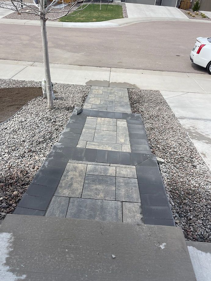 A sidewalk with a car parked on the side of it.