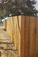 A wooden fence is sitting next to a dirt path.