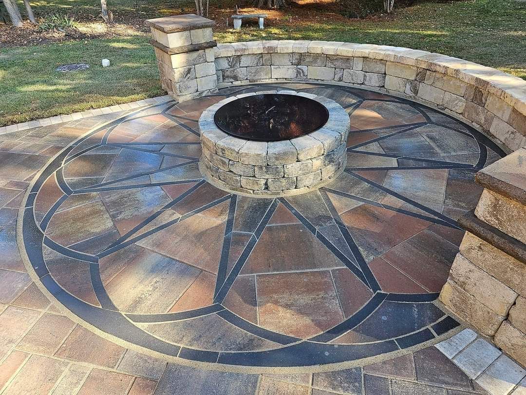 A fire pit is surrounded by a circular pattern on a patio.