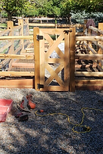 A wooden gate is being built into a wooden fence.
