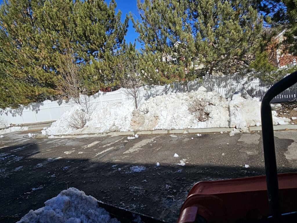 A car is parked in a parking lot with snow on the ground.