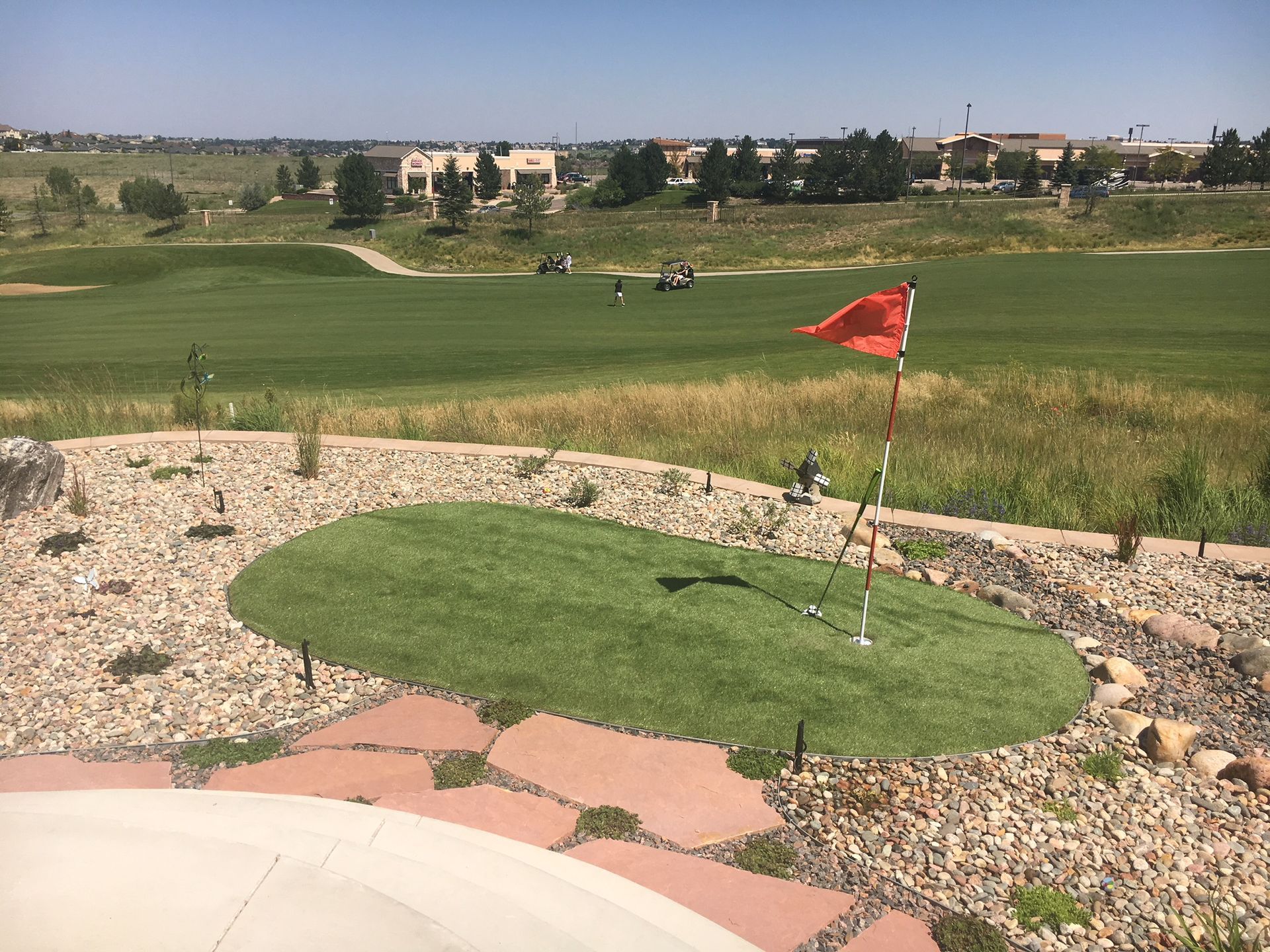 A golf course with a red flag on the green
