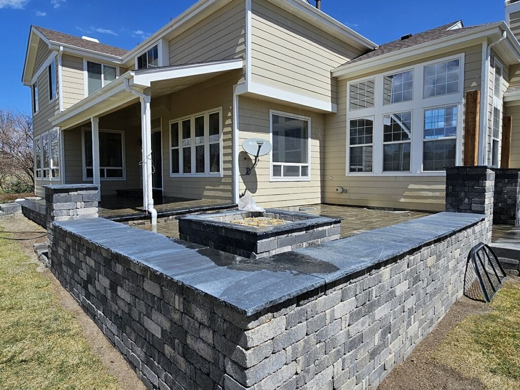 A large house with a brick wall in front of it.