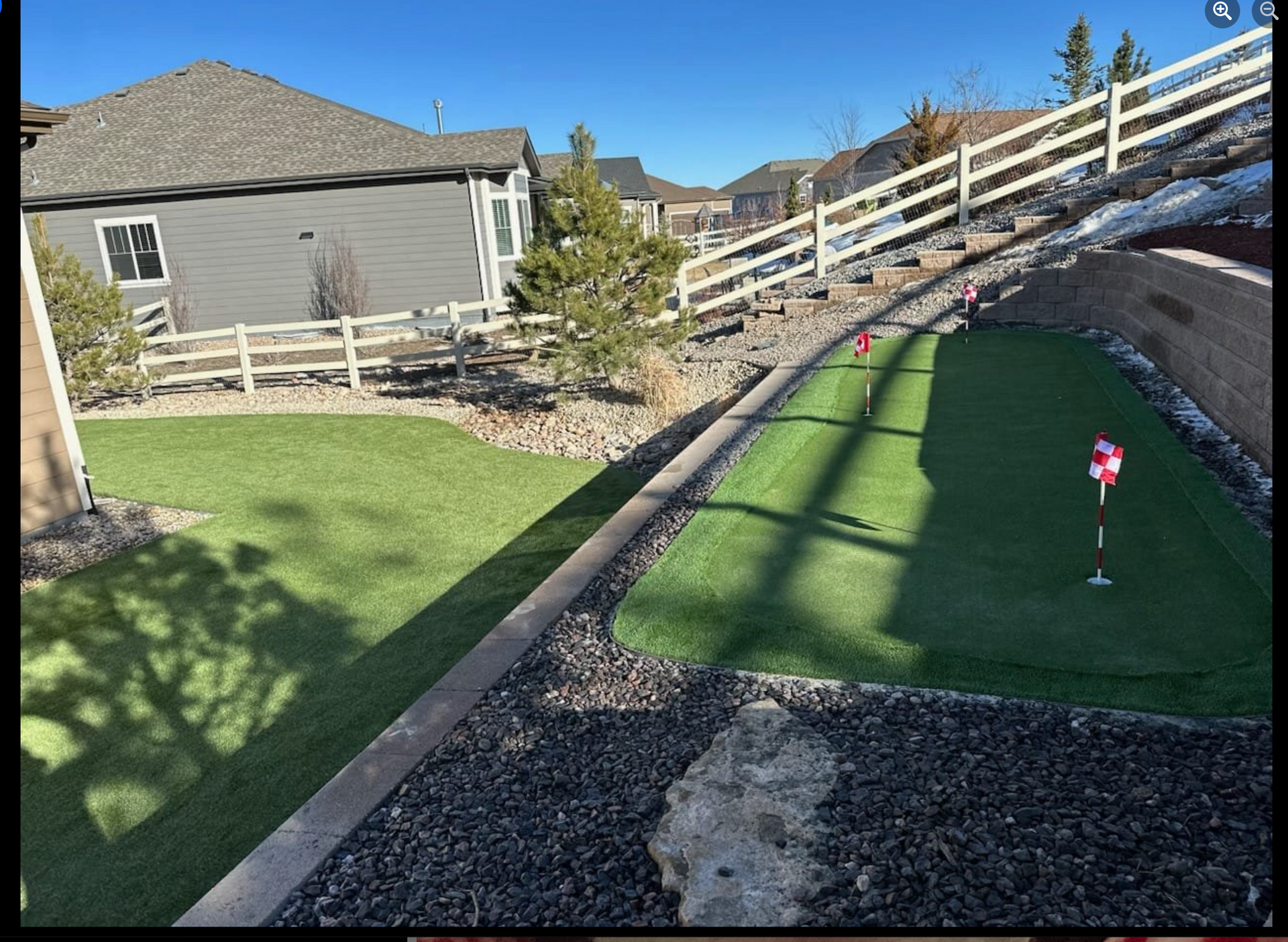 A putting green with a house in the background