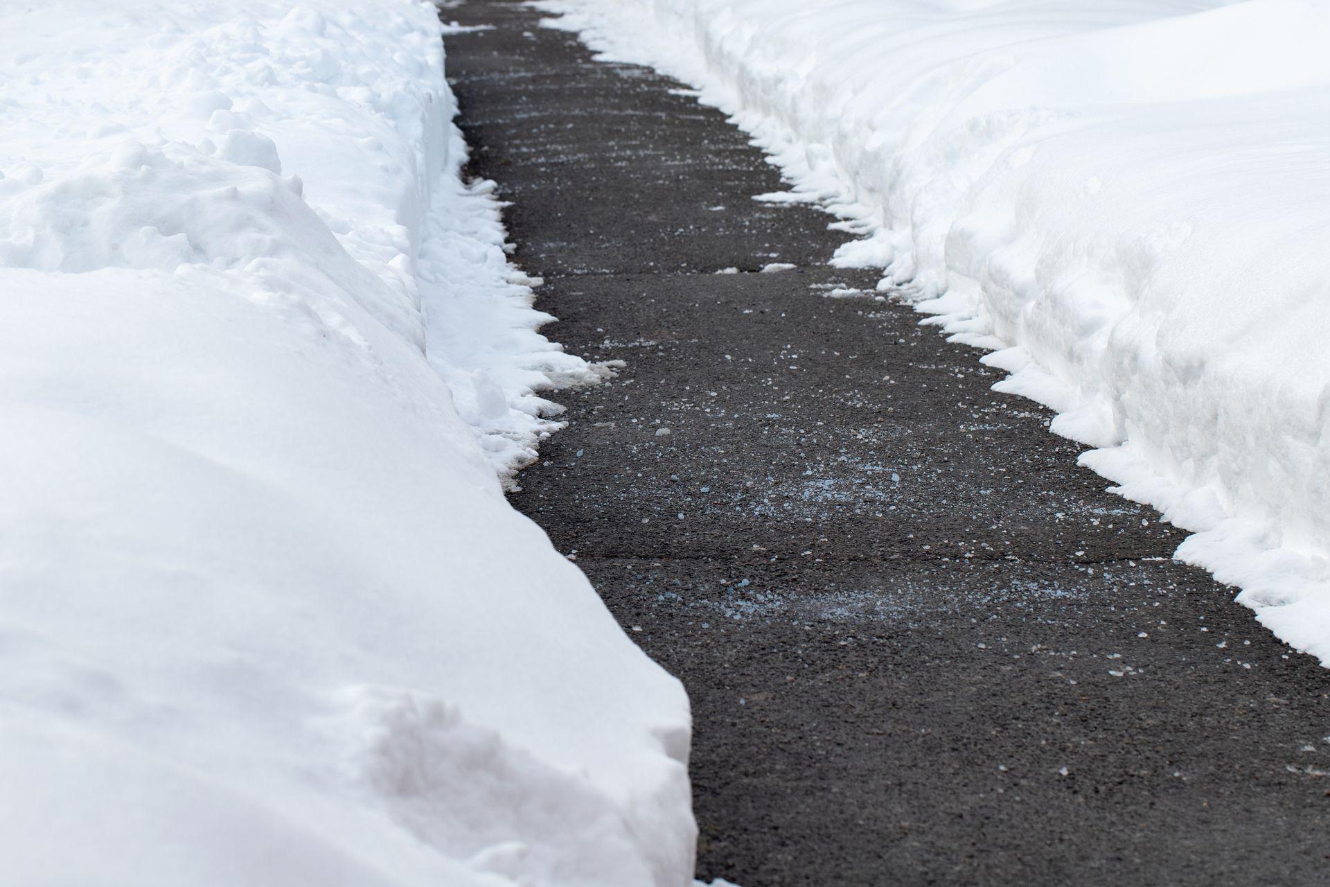 Snow-covered path with high snow banks on either side.