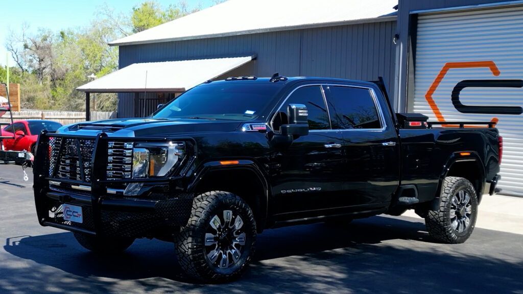 A black truck is parked in front of a building.