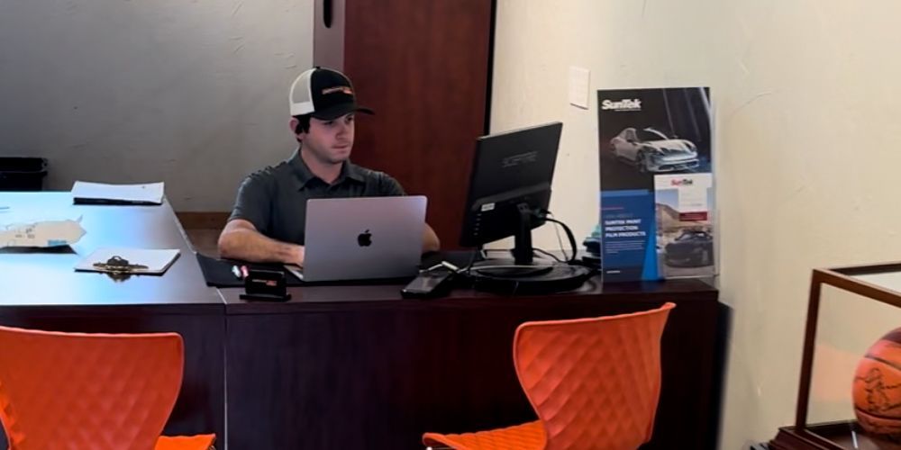 A man is sitting at a desk using a laptop computer.