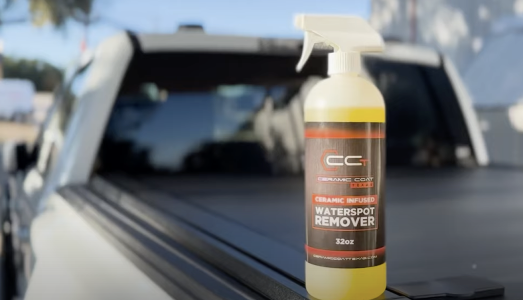 A bottle of waterspot remover is sitting on the back of a truck.