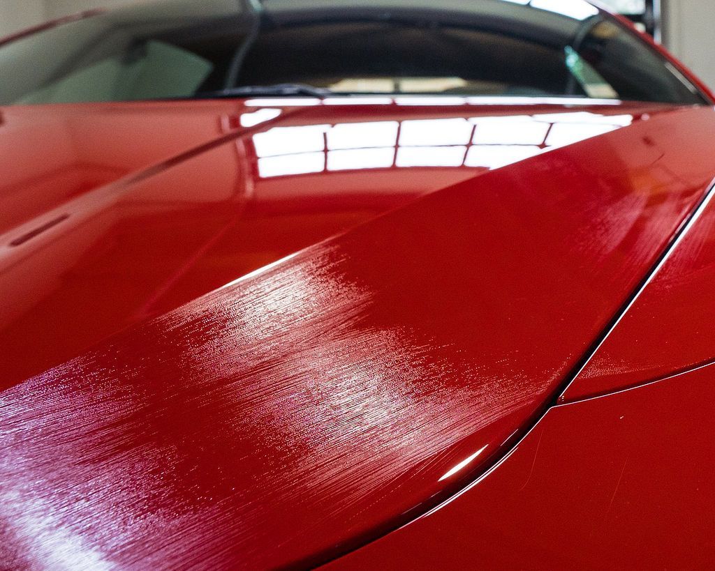 A close up of the hood of a red car