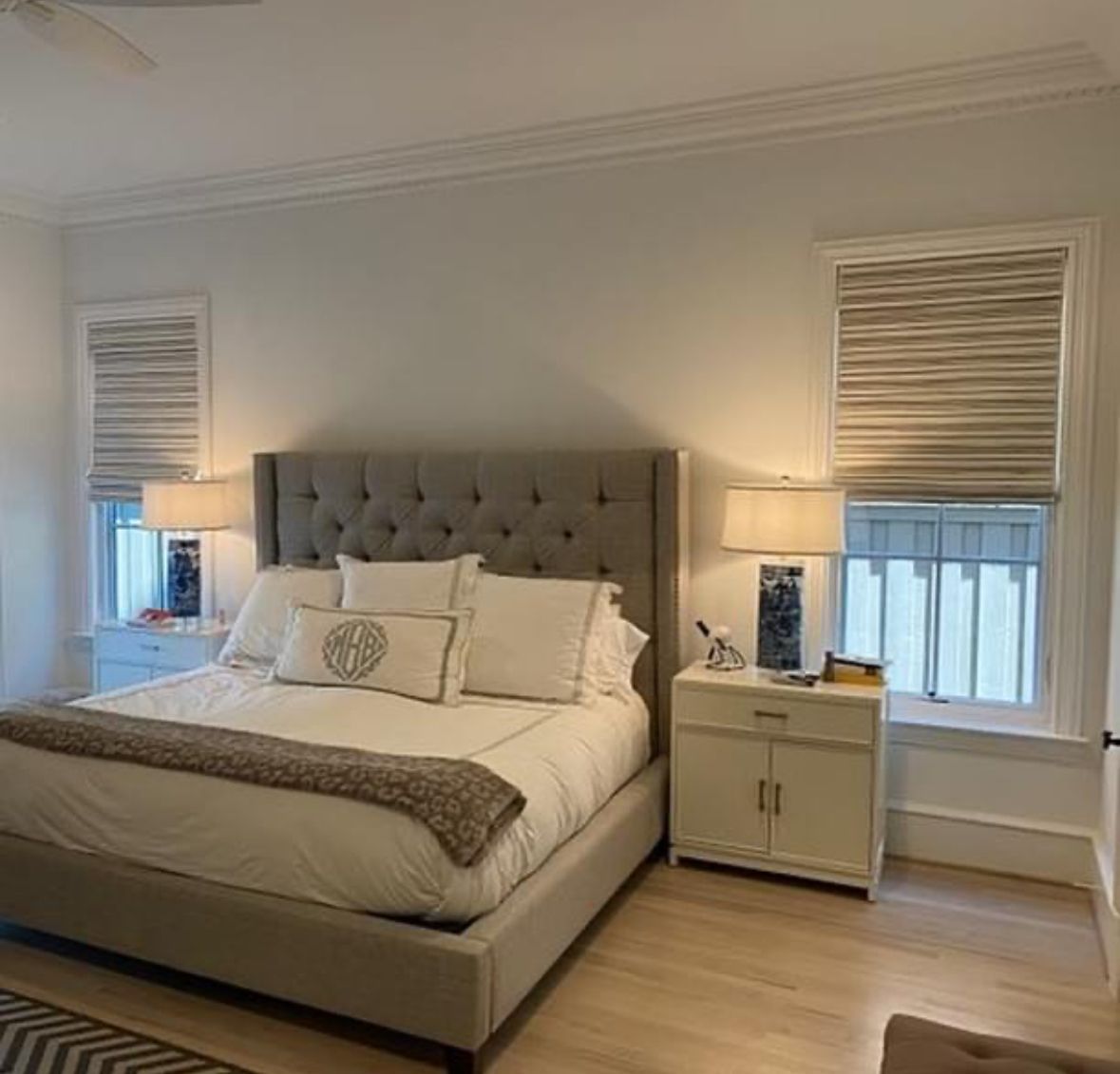 A bedroom with a large bed and two windows