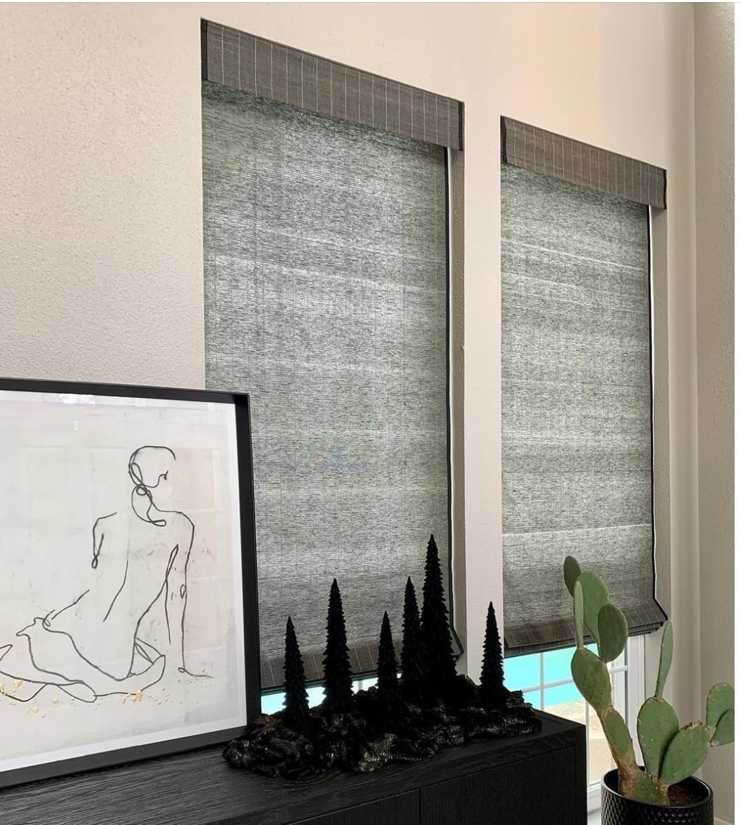 There is a picture of a woman sitting on the floor next to a window.