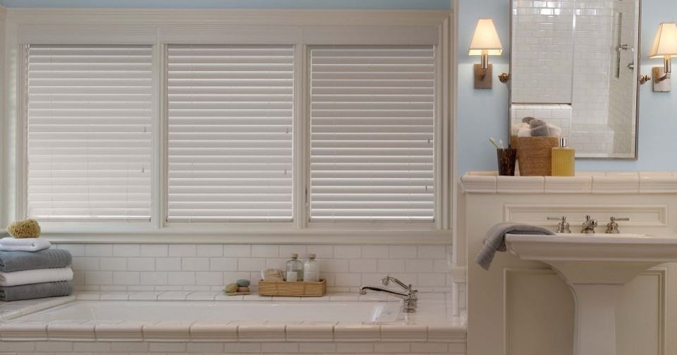 A window with wooden blinds and a light hanging from the ceiling.