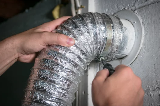 A person is fixing a duct with a pair of pliers.