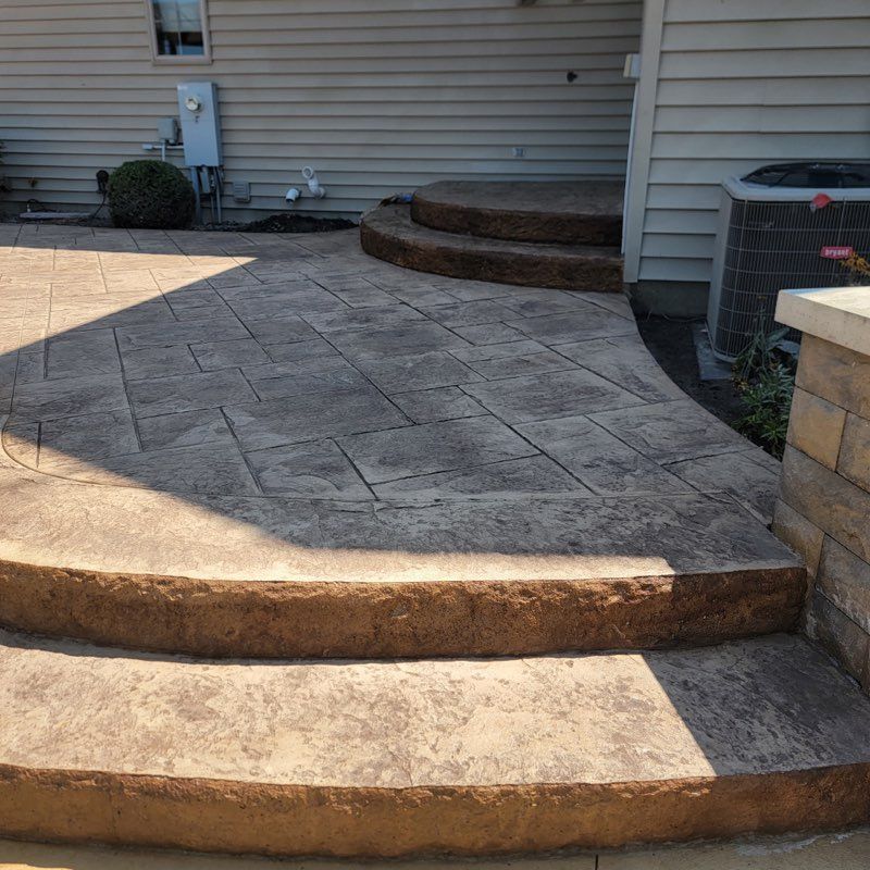 A concrete walkway with steps leading up to a house.