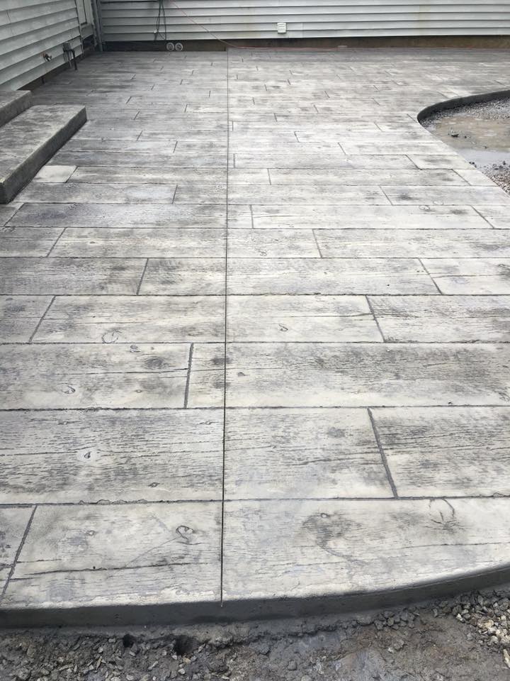 A concrete patio with steps leading to a house.